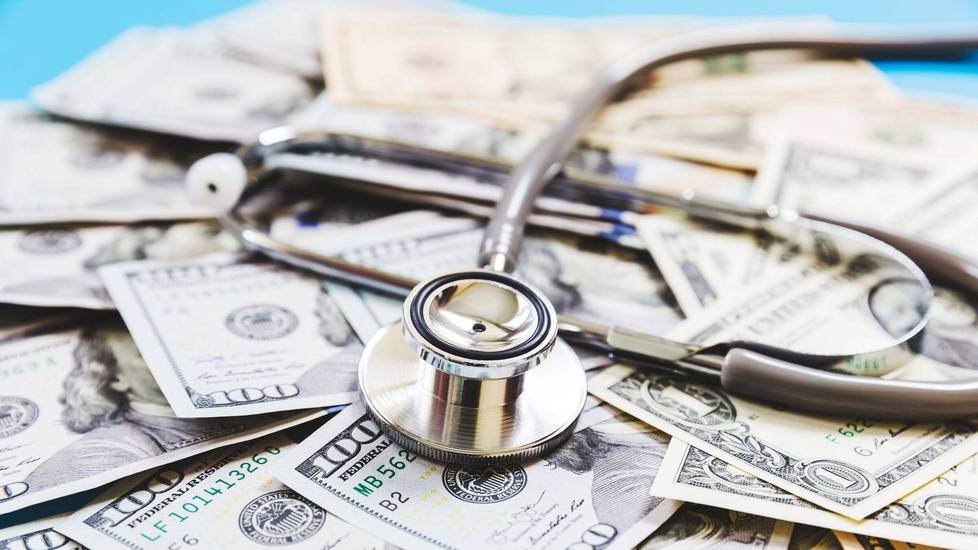 Stethoscope on top of pile of money