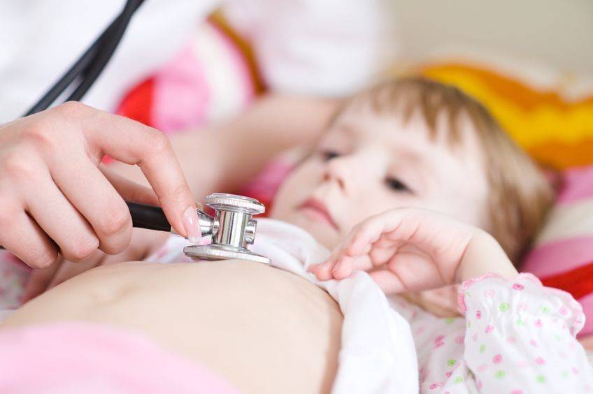 Child at doctor's office with stethoscope over heart